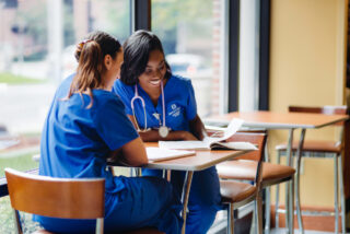 Two nursing program students look over an assignment